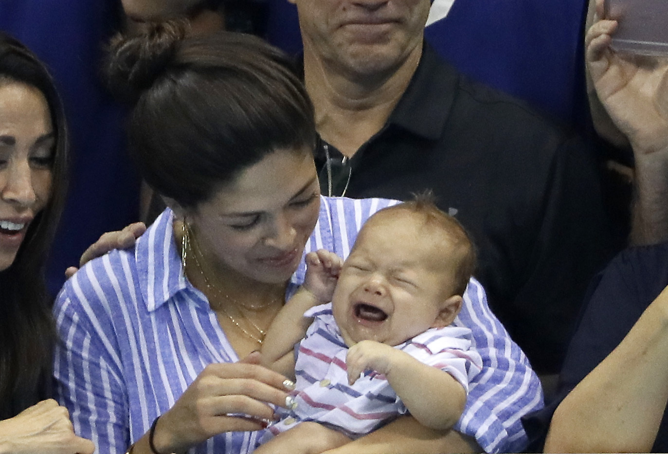 United States' Michael Phelps fiancee, Nicole Johnson, holds his baby son Boomer during the swimming competitions at the 2016 Summer Olympics, Wednesday, Aug. 10, 2016, in Rio de Janeiro, Brazil. (AP Photo/David J. Phillip )