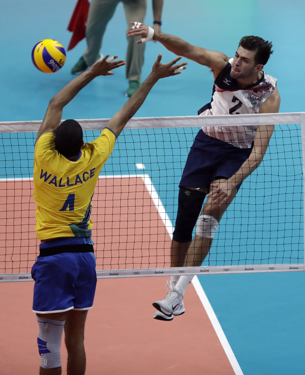 United States' Aaron Russell, right, spikes the ball over Brazil's Wallace de Souza during a men's preliminary volleyball match at the 2016 Summer Olympics in Rio de Janeiro, Brazil, Thursday, Aug. 11, 2016. (AP Photo/Jeff Roberson)