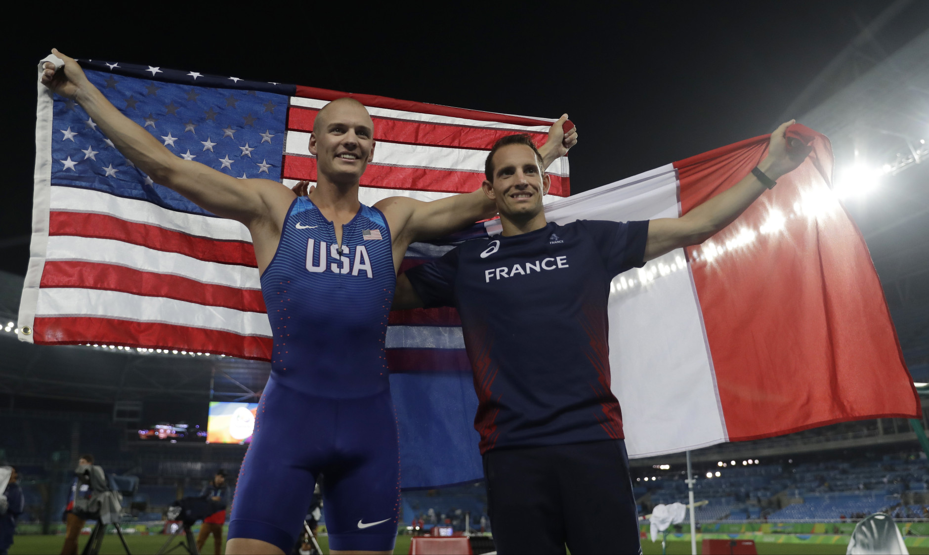 United States' Sam Kendricks and France's Renaud Lavillenie celebrate with their country's flags after the men's pole final, during the athletics competitions of the 2016 Summer Olympics at the Olympic stadium in Rio de Janeiro, Brazil, Tuesday, Aug. 16, 2016. (AP Photo/Matt Dunham)
