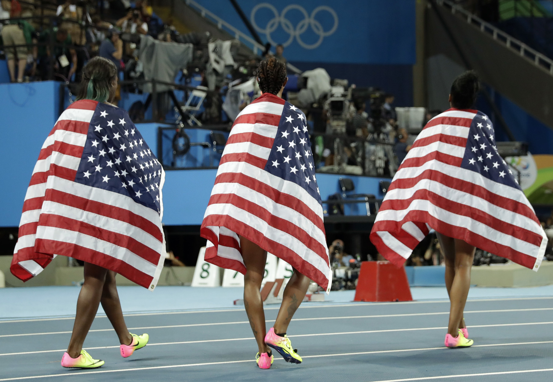 Gold medal winner Brianna Rollins, center, silver medal winner, Nia Ali, left , and bronze medal winner Kristi Castlin, all from the United States, pose with their country's flag after the 100-meter hurdles final, during the athletics competitions of the 2016 Summer Olympics at the Olympic stadium in Rio de Janeiro, Brazil, Wednesday, Aug. 17, 2016. (AP Photo/Matt Dunham)