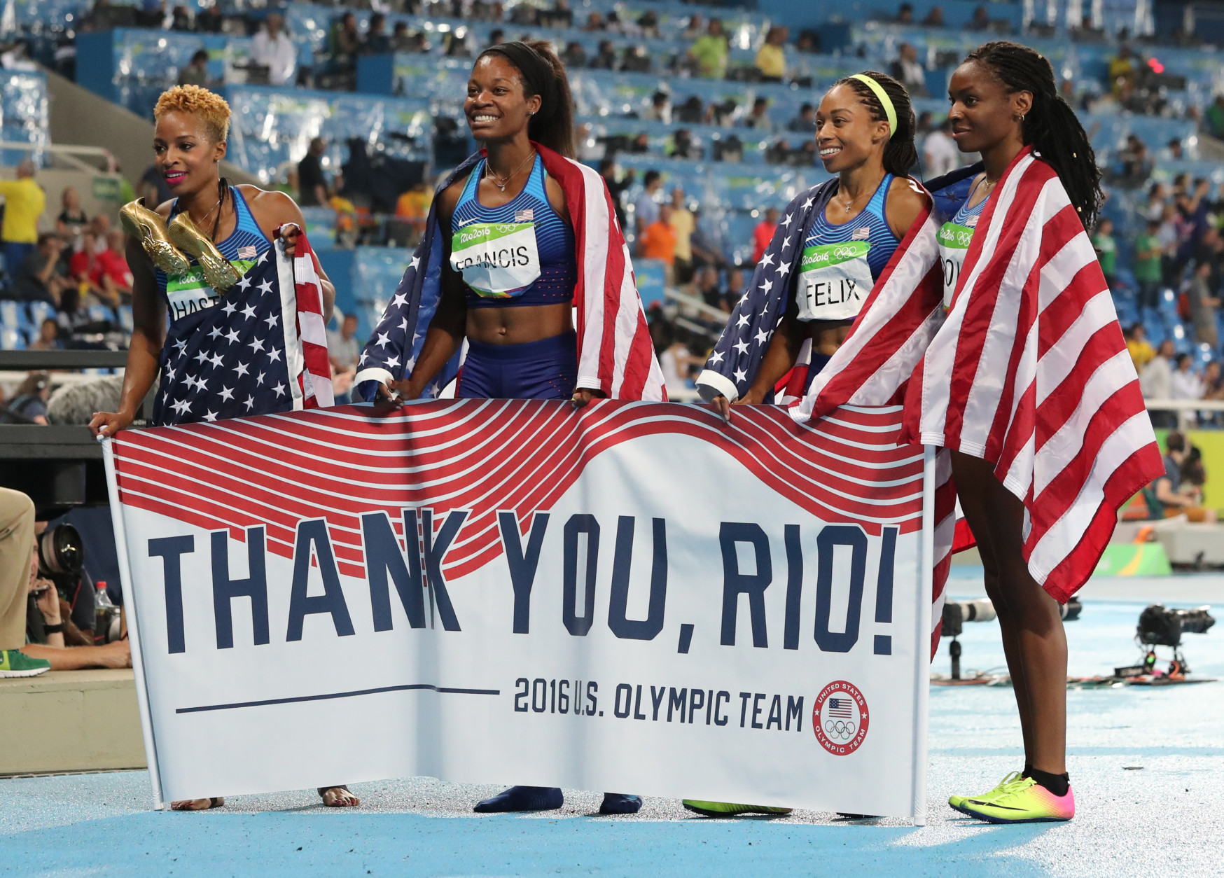 United States' Courtney Okolo, Natasha Hastings, Phyllis Francis and Allyson Felix hold a sign and wear their nation's flag after winning the gold in the women's 4x400 meter relay during athletics competitions at the Summer Olympics inside Olympic stadium in Rio de Janeiro, Brazil, Saturday, Aug. 20, 2016. (AP Photo/Lee Jin-man)