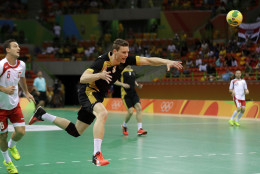 Germany's Tobias Reichmann scores a goal past Poland's Przemyslaw Krajewski, left, during the men's bronze medal handball match between Germany and Poland at the 2016 Summer Olympics in Rio de Janeiro, Brazil, Sunday, Aug. 21, 2016. (AP Photo/Ben Curtis)