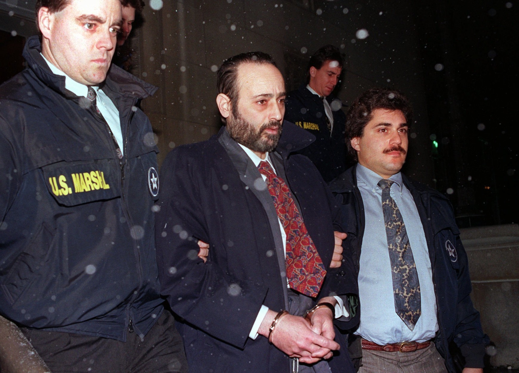 In this Jan. 11, 1993 file photo, "Crazy" Eddie Antar, center, founder of the Crazy Eddie electronics store chain, is led in handcuffs after being extradited from Israel.  The Bloomfield-Cooper funeral home in Ocean Township, New Jersey, confirmed Sunday, Sept. 11, 2016,  that Antar died Saturday. He was 68.  (AP Photo/Dan Hulshizer, file)