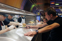Chef Bobby Flay, right, checks an order from the kitchen at his new restaurant, Bobby's Burger Palace, opening inside Horseshoe Casino Cincinnati, Monday, March 4, 2013, in Cincinnati. The casino is set to open to the public Monday evening. March 4. (AP Photo/Al Behrman)