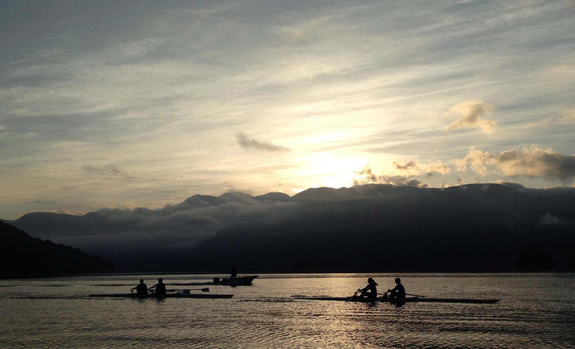 Rowers are silhouetted against the mountains as the sun rises in Deep Cove in North Vancouver, British Columbia, Tuesday, June 3, 2014. (AP Photo/The Canadian Press, Jonathan Hayward)