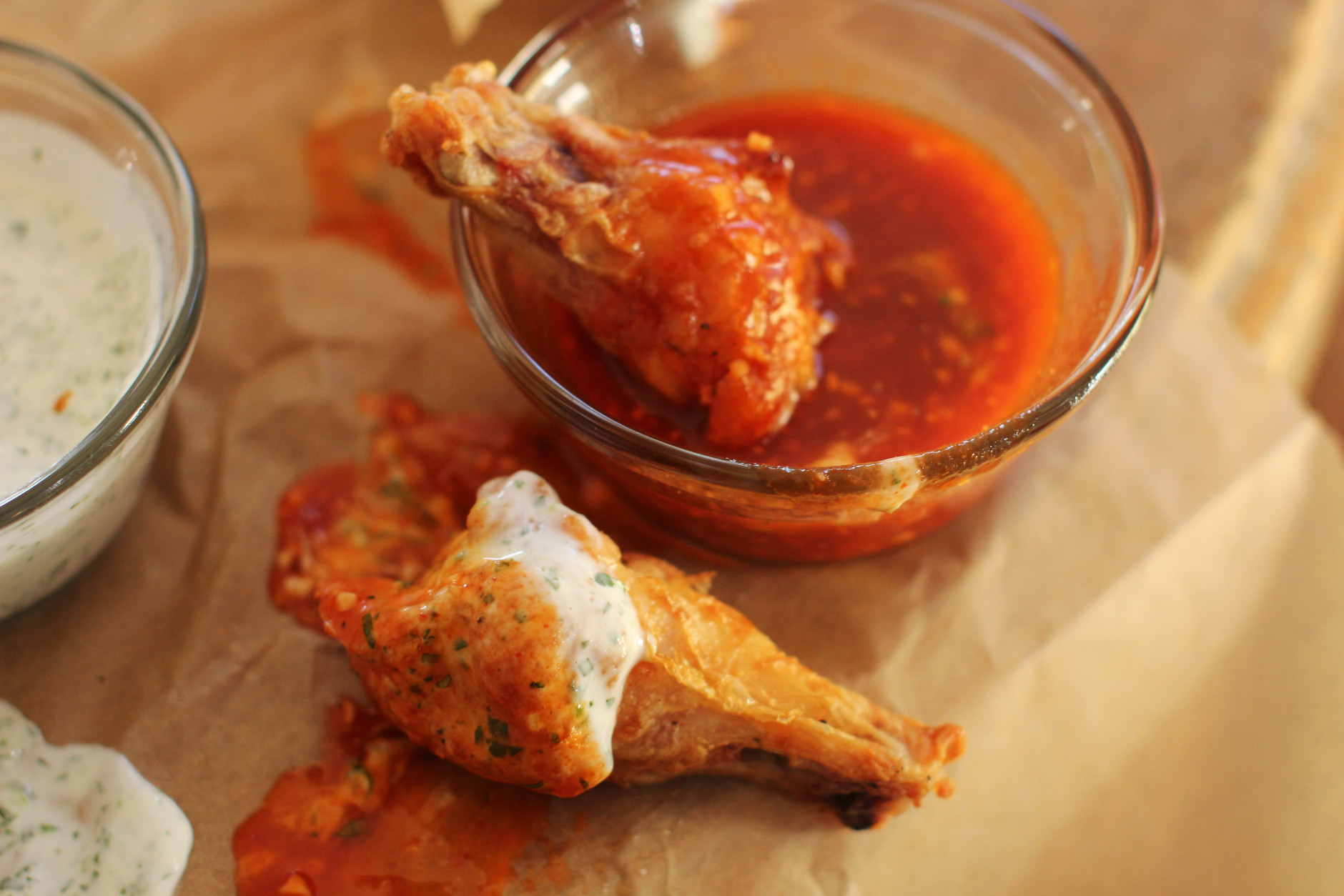 This Nov. 16, 2015 photo shows hands off party wings with cilantro sour cream dip and honey sriracha in Concord, N.H. These wings require almost no effort from you. The secret is baking powder. (AP Photo/Matthew Mead)