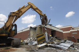 A demolition machine begins the demolition of the Louisa County High School in Mineral, Va., Tuesday, Aug. 21, 2012.  The school was damaged beyond repair during the earthquake last year. ( AP Photo/Steve Helber)