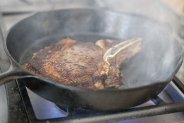 In this May 5, 2014 photo, a steak is pan seared in Concord, N.H. Certain small steps - heating the pan properly, patting the meat dry before putting it in the pan - help ensure success. (AP Photo/Matthew Mead)