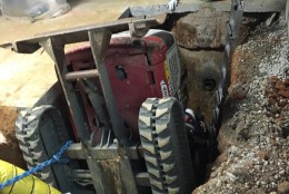 This Bobcat got lodged into this seven-inch trench while excavating a sewer line at Charles River Labs in Rockville, Md. The operator suffered non-life threatening injuries. (Pete Piringer/Montgomery Count Fire & Rescue Service via Twitter)