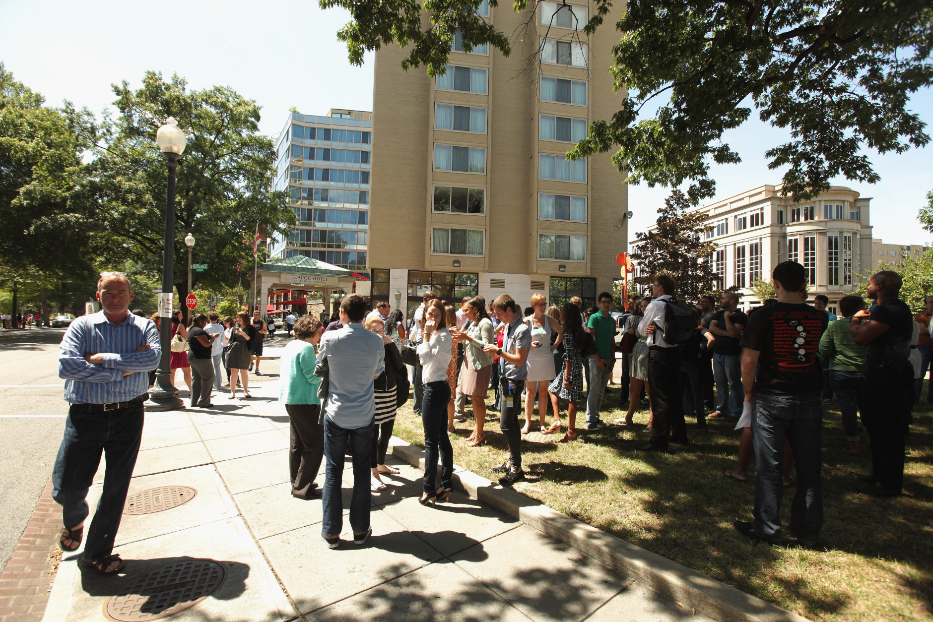 WASHINGTON, DC - AUGUST 23:  People try to communicate on their cell phones after being evacuated from their building after a 5.8 magnitude earthquake struck the east coast August 23, 2011 in Washington, DC.  (Photo by Chip Somodevilla/Getty Images)