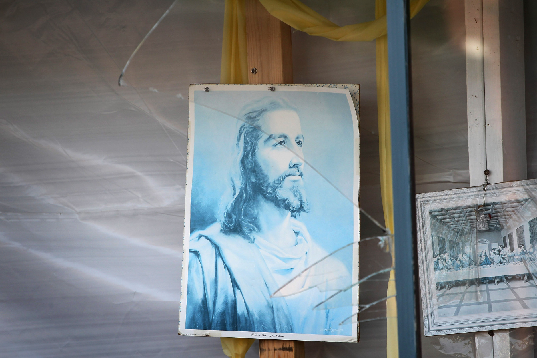 MINERAL, VA - AUGUST 24: A faded picture of Jesus hangs behind a window of a storefront shattered by yesterday's 5.8 earthquake August 24, 2011 in Mineral, Virginia. The epicenter of the quake, the East Coast's largest since 1944, was located a few miles outside of Mineral, a town of 430 people located about 50 miles west of Richmond.  (Photo by Scott Olson/Getty Images)