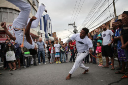 RIO DE JANEIRO, BRAZIL - AUGUST 03:  Brazilians perform capoeira, a Brazilian martial art mixing dance and music, ahead of the arrival of the Olympic torch relay in Rio's North Zone on August 3, 2016 in Rio de Janeiro, Brazil. The Rio 2016 Olympic Games commence on August 5.  (Photo by Mario Tama/Getty Images)