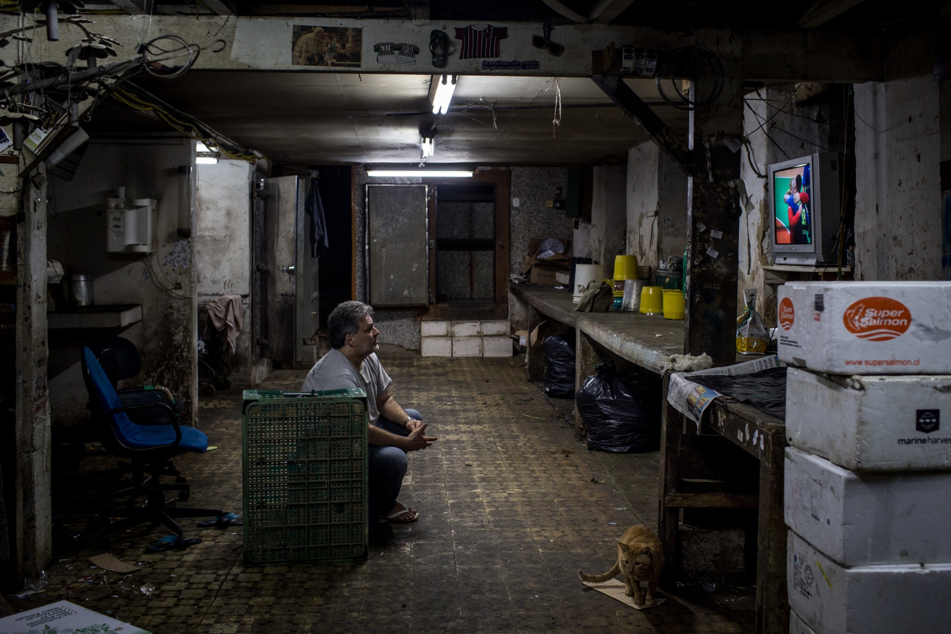 RIO DE JANEIRO, BRAZIL - AUGUST 15:  A man watches the Olympic games on his tv in the basement of a shop on August 15, 2016 in Rio de Janeiro, Brazil. Brazil is currently hosting the 2016 Summer Olympic games despite the dismissal of President Dilma Rousseff, pollution concerns, ongoing crime problems and a failing economy. Around 1.4 million residents, or approximately 22 percent of Rio's population, reside in favelas which often lack proper sanitation, health care, education and security, for many of these residents watching the Olympic games on tv is their only access to the event.  (Photo by Chris McGrath/Getty Images)