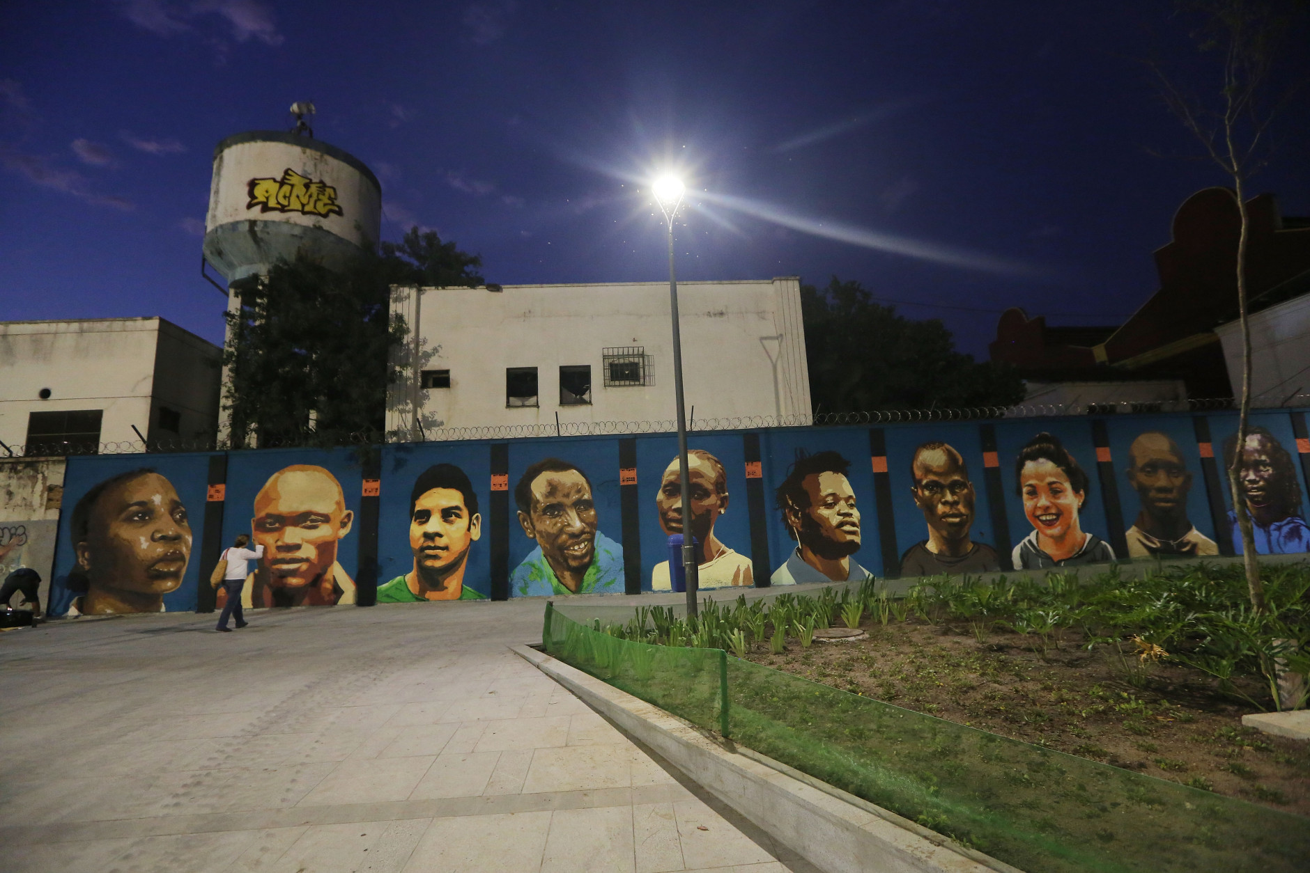 RIO DE JANEIRO, BRAZIL - AUGUST 17:  Dusk descends over a new mural of street art honoring the first Olympic refugee team during the Rio 2016 Olympic Games on August 17, 2016 in Rio de Janeiro, Brazil. The graffitti, created by the artists Rodrigo Sini and Cety Soledade, honors the stateless refugees, six men and four women, who hail from South Sudan, Syria, the Deomocratic Republic of Congo and Ethiopia.  (Photo by Mario Tama/Getty Images)