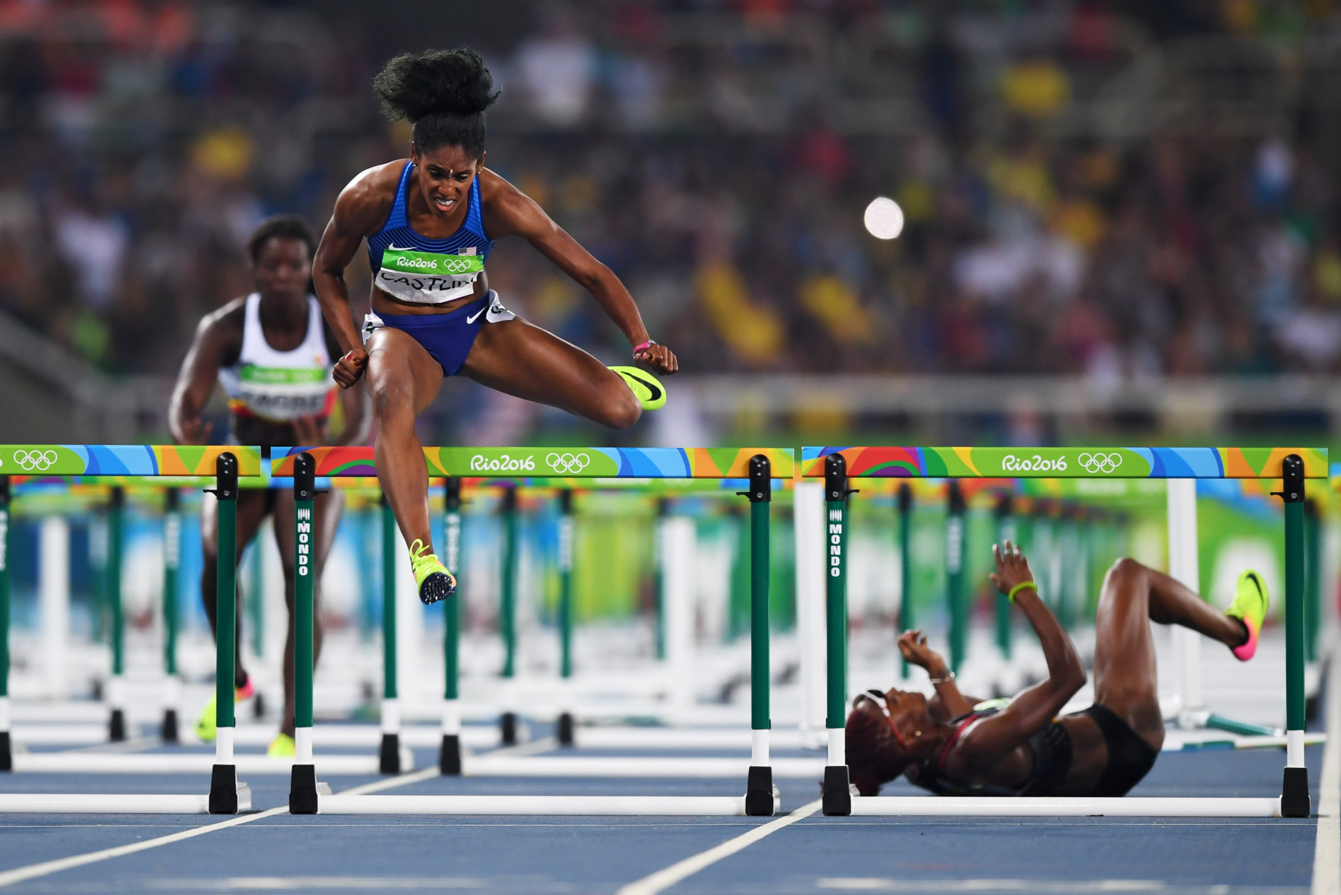 RIO DE JANEIRO, BRAZIL - AUGUST 17:  Kristi Castlin of the United States competes in the Women's 100m Hurdles Semifinals as Nikkita Holder of Canada (R) falls down on Day 12 of the Rio 2016 Olympic Games at the Olympic Stadium on August 17, 2016 in Rio de Janeiro, Brazil.  (Photo by Shaun Botterill/Getty Images)