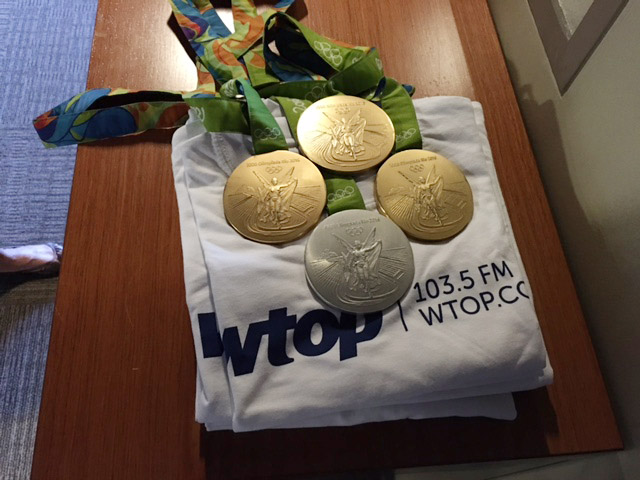 Four of the five medals that Katie Ledecky won during the Rio Olympics are displayed on some WTOP T-shirts on Wednesday, Aug. 29, 2016. (WTOP/Sue Rushkowski)