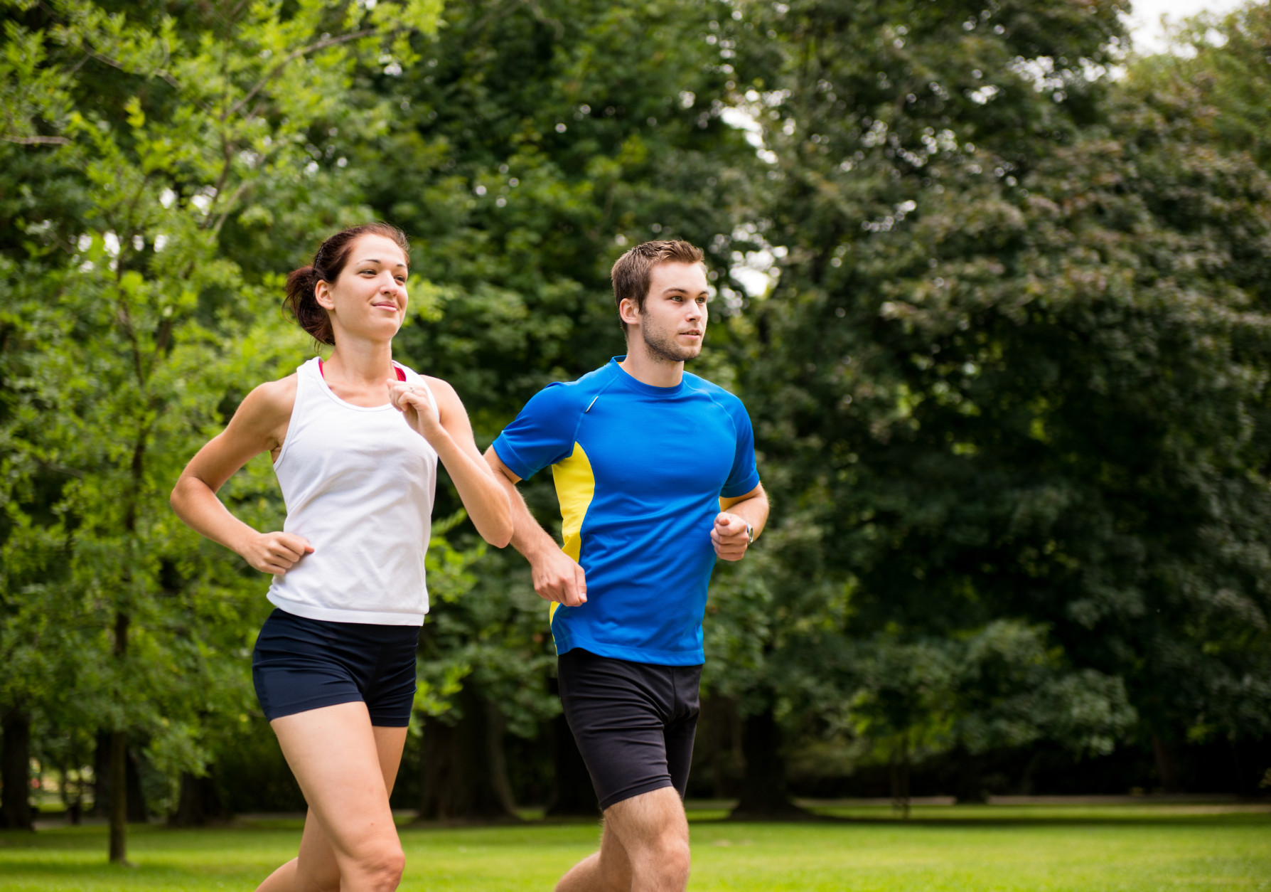 Fitness couple - young man and woman jogging outdoor in nature