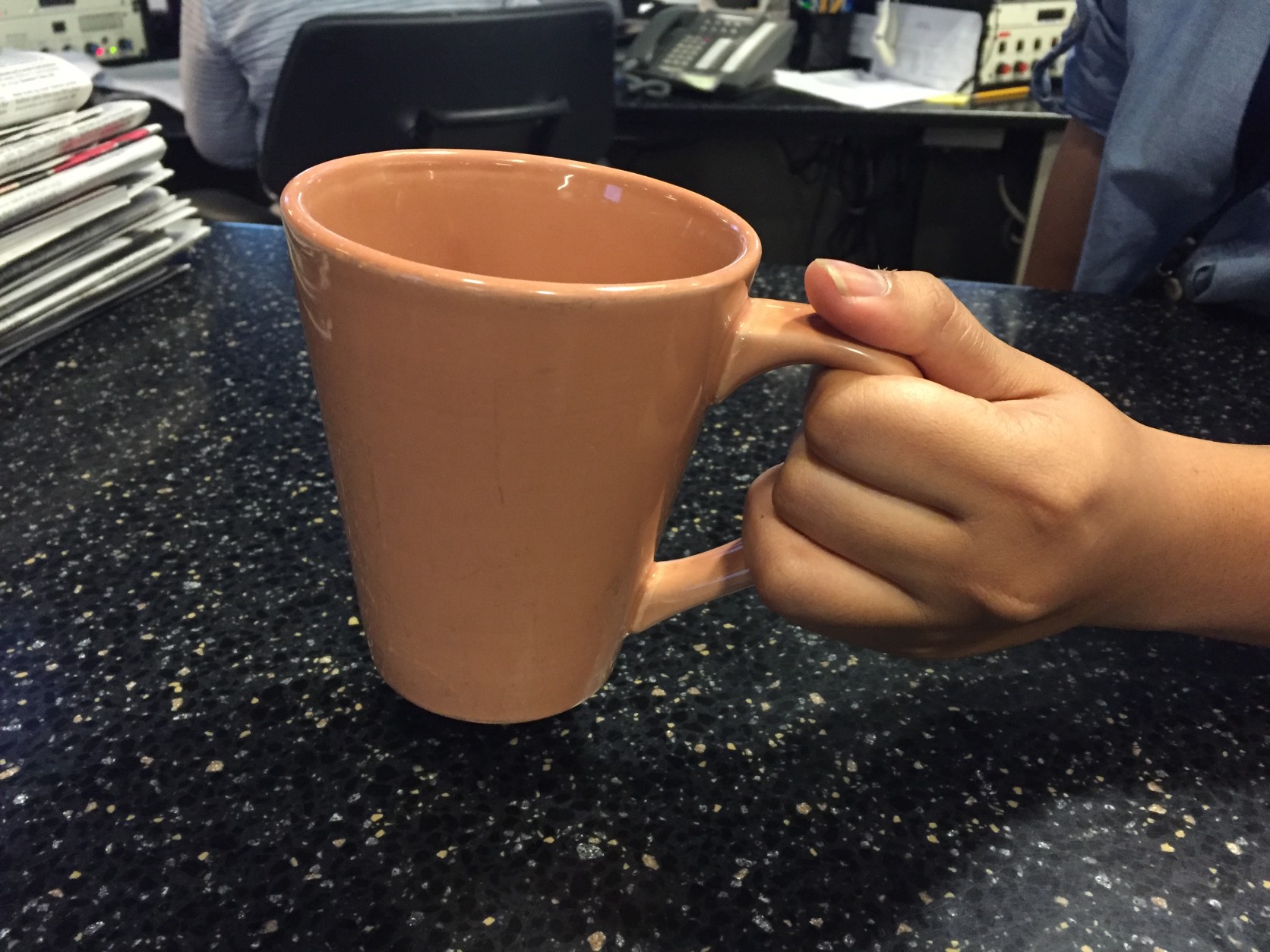The usual way of holding a coffee cup while walking may not be the best way to avoid spills. (WTOP/Michelle Basch)