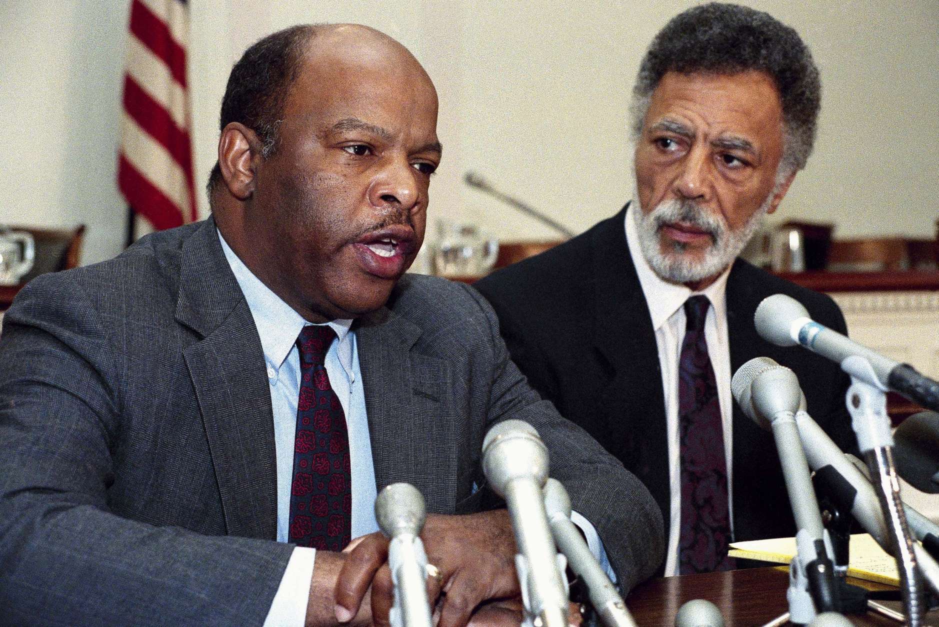 Reps. John Lewis, D-Ga., left, Ron Dellums, D-Calif., right, face reporters on Capitol Hill Sunday, Aug. 13, 1989 where they discuss the reported finding of a plane which carried Rep. Mickey Leland, D-Texas, and others aboard in Ethiopia. U.S. officials said no survivors were found. (AP Photo/Doug Mills)