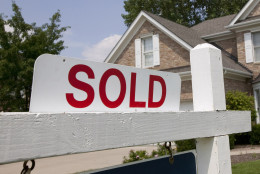 Sold house sign in Midwest suburban setting. Focus on sign.