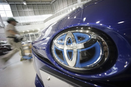 A worker walks past a Toyota car at a Toyota showroom in Tokyo, Wednesday, June 29, 2016. Toyota is recalling 1.43 million vehicles globally for defective air bags that arenâ€™t part of the massive recalls of Takata air bags, the Japanese automaker said Wednesday. (AP Photo/Eugene Hoshiko)
