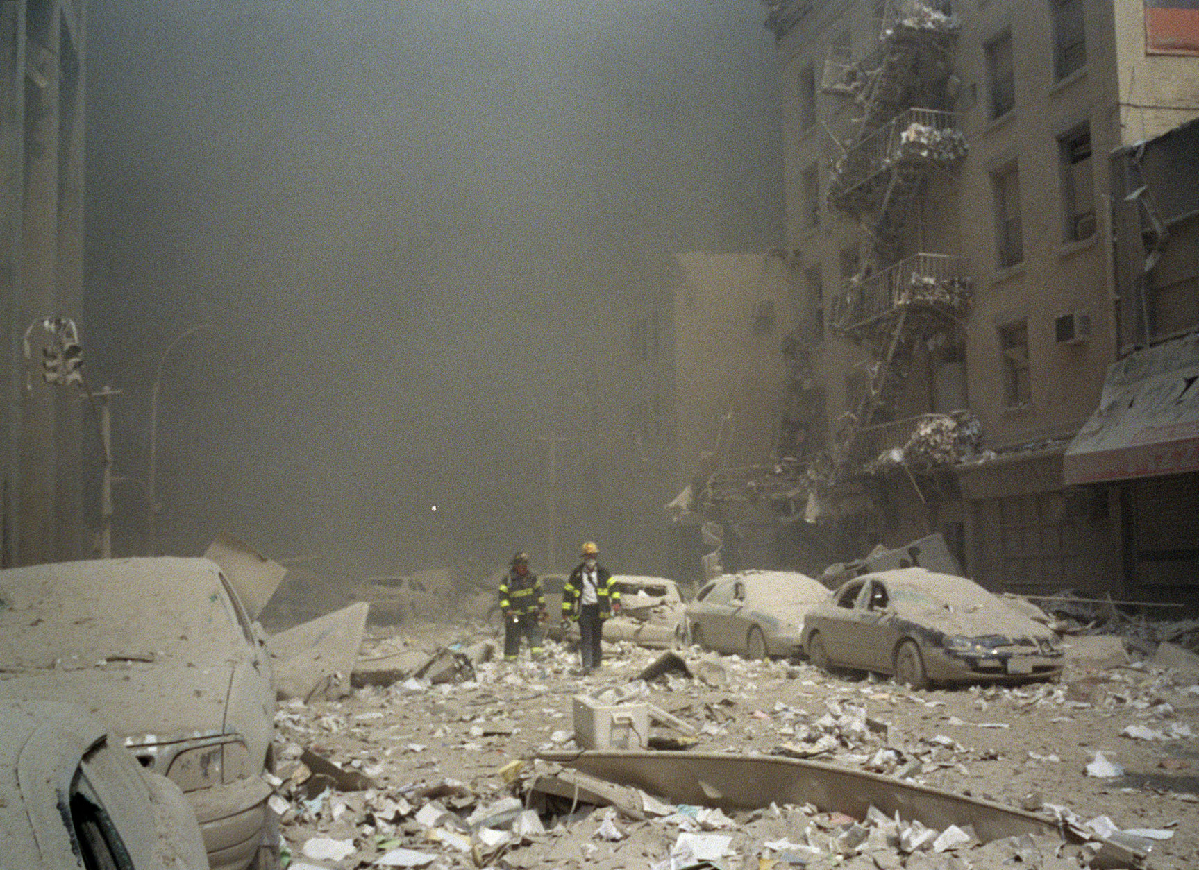 FIremen walk through a dust and debris covered street in lower Manhattan Tuesday, Sept. 11, 2001, after a terrorist attack at the World Trade Center. Two jet planes were crashed into the twin towers, collapsing them and covering the area with the debris.(AP Photo/Richard Cohen)