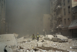 FIremen walk through a dust and debris covered street in lower Manhattan Tuesday, Sept. 11, 2001, after a terrorist attack at the World Trade Center. Two jet planes were crashed into the twin towers, collapsing them and covering the area with the debris.(AP Photo/Richard Cohen)