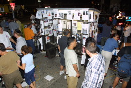 In this September 13, 2001 photograph, people gather around missing person posters on a telephone booth after the September 11 terrorist attacks on the World Trade Center in New York City.(AP Photo/David Karp)