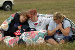 From left, Shannon Barry, Lisa Starr and Michelle Wagner, all of Hershey, Pa., react as they listen to a memorial service for victims of Flight 93 near Shanksville, Pa., Wednesday, Sept. 11, 2002. President Bush will lay a wreath at the crash site later in the day to mark the anniversary of the terrorist attacks. (AP Photo/Julie Jacobson)