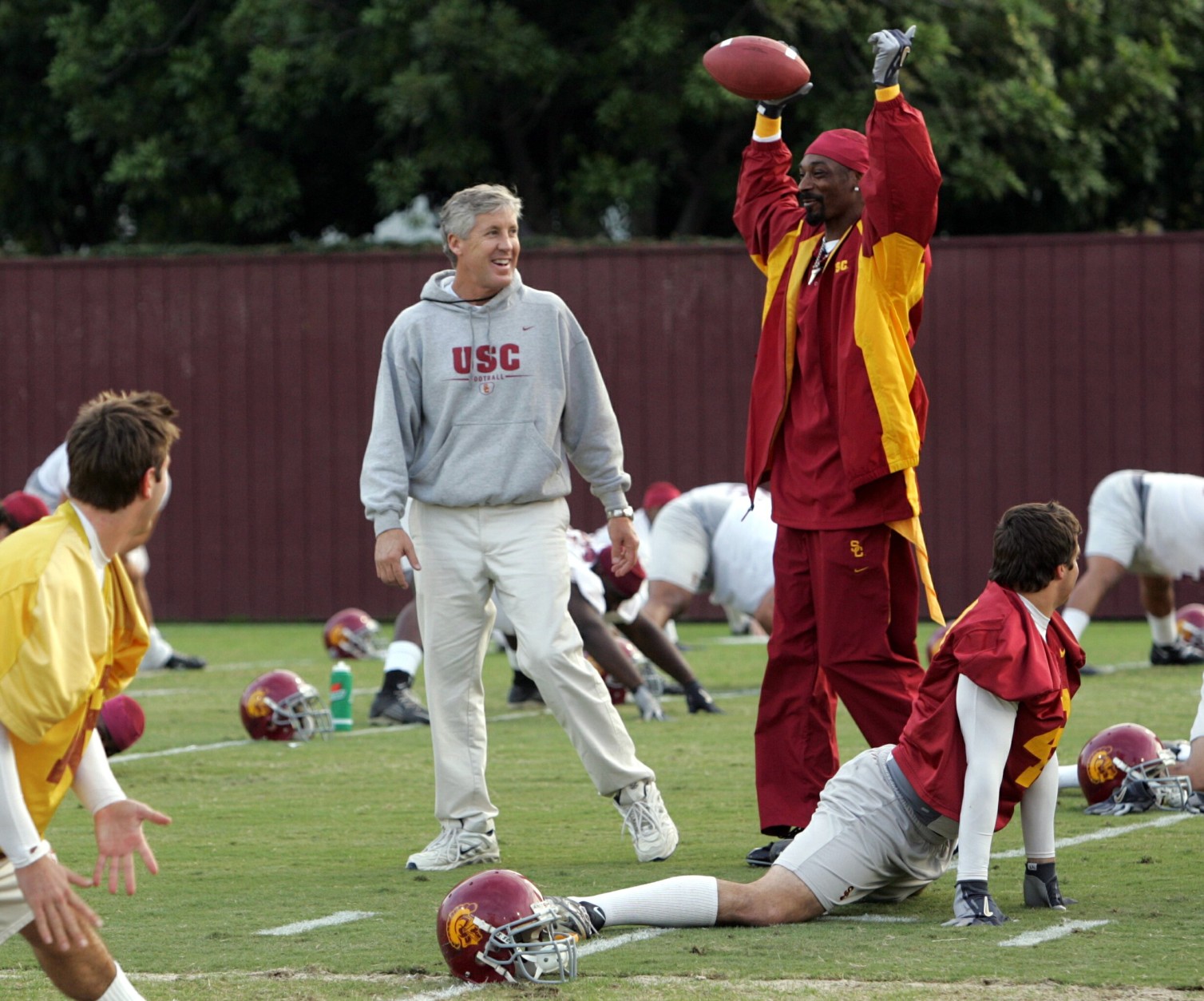 Rapper Snoop Dogg makes a visit to the University of California football team practice Tuesday, Nov. 16, 2004 in Los Angeles as coach Pete Carroll, left, looks on. Snoop donned football gloves, a red USC sweat suit and ran drills with the team. (AP Photo/Reed Saxon)