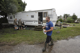 Spyridon Aibejeris helps his neighbors pull out a trailer off his property along the Gulf of Mexico in advance of Tropical Storm Hermine Thursday, Sept. 1, 2016, in Keaton Beach, Fla. Hermine strengthened into a hurricane Thursday and steamed toward Florida's Gulf Coast, where people put up shutters, nailed plywood across store windows and braced for the first hurricane to hit the state in over a decade. (AP Photo/Chris O'Meara)