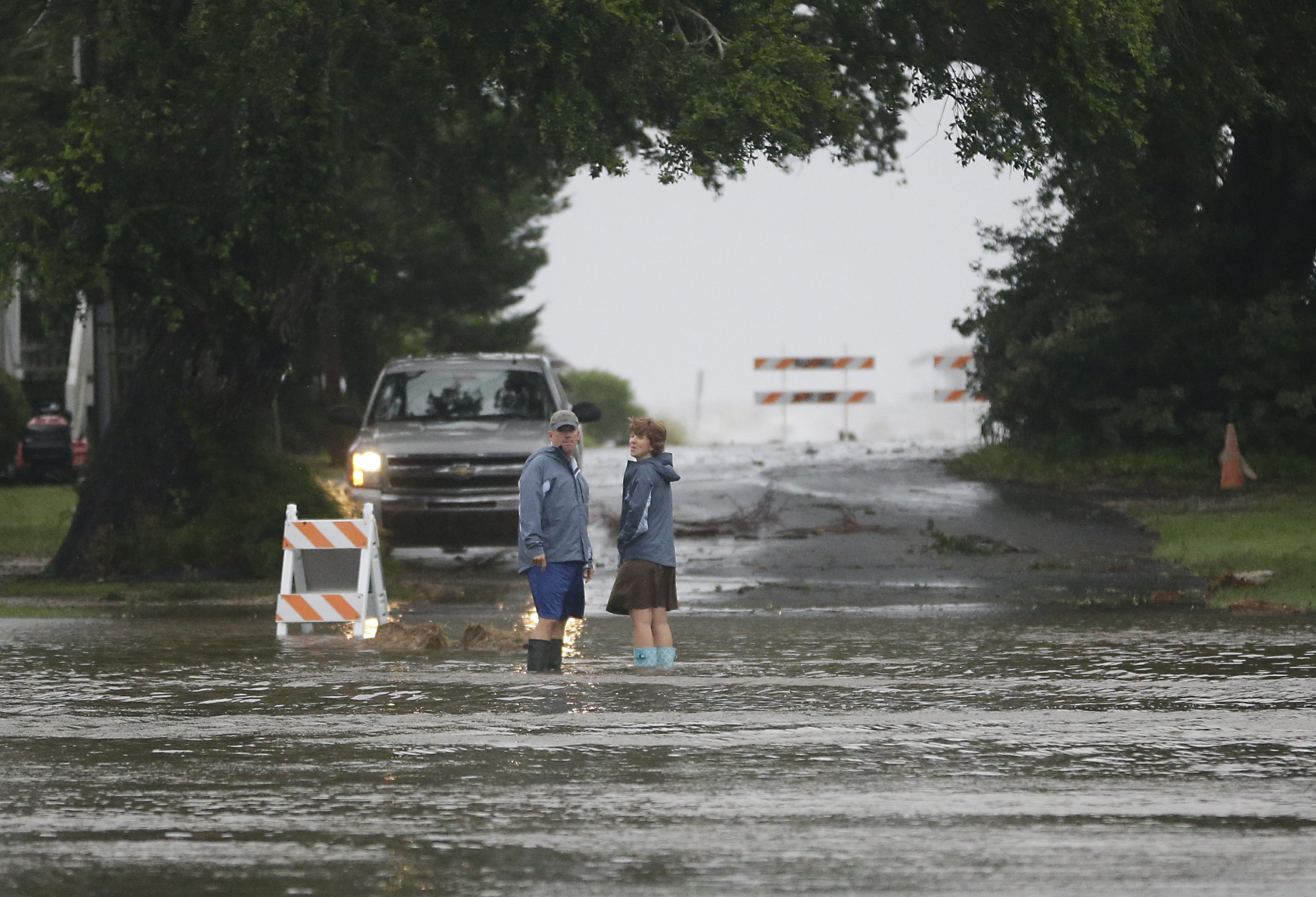 Residents check on a flooded street before turning back as Hurricane Hermine nears the Florida coast, Thursday, Sept. 1, 2016, in Cedar Key, Fla. Tropical Storm Hermine strengthened into a hurricane Thursday and steamed toward Florida's Gulf Coast, where people put up shutters, nailed plywood across store windows and braced for the first direct hit on the state from a hurricane in over a decade. (AP Photo/John Raoux)