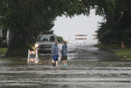 Residents check on a flooded street before turning back as Hurricane Hermine nears the Florida coast, Thursday, Sept. 1, 2016, in Cedar Key, Fla. Tropical Storm Hermine strengthened into a hurricane Thursday and steamed toward Florida's Gulf Coast, where people put up shutters, nailed plywood across store windows and braced for the first direct hit on the state from a hurricane in over a decade. (AP Photo/John Raoux)