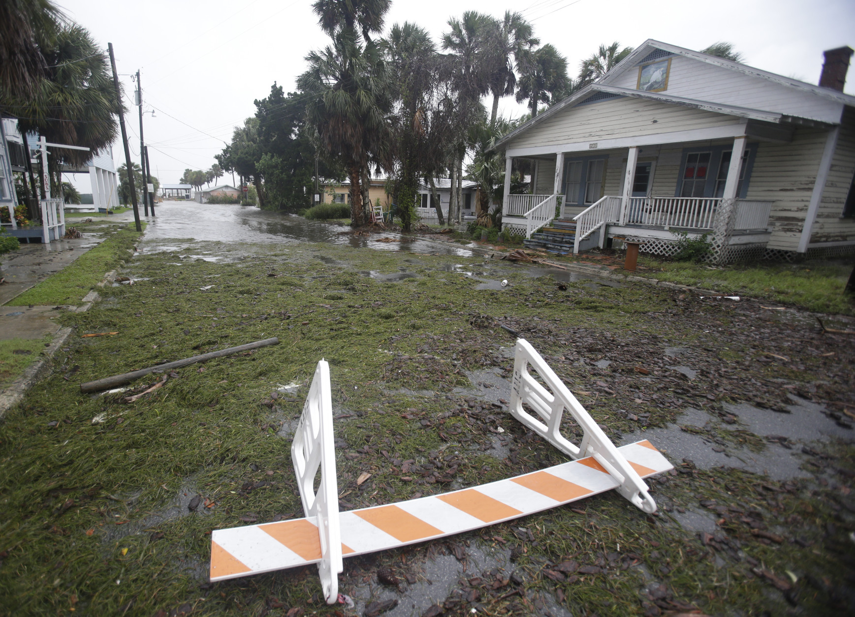 Seaweed covers a flooded street in Cedar Key, Fla. as Hurricane Hermine nears the Florida coast, Thursday, Sept. 1, 2016. Hurricane Hermine gained new strength Thursday evening and roared ever closer to Florida's Gulf Coast, where rough surf began smashing against docks and boathouses and people braced for the first direct hit on the state from a hurricane in over a decade. (AP Photo/John Raoux)