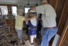 Bobbi Pattison, left, with help from her neighbors Hugh and Harriet Oglesby, stands up a sea captain statue carved out of wood from a 1993 storm at her home Friday, Sept. 2, 2016, in Steinhatchee, Fla. Hurricane Hermine was downgraded to a tropical storm after it made landfall, as it moves over Georgia, but the U.S. National Hurricane Center says winds are increasing along the Southeast coast and flooding rains continue. (AP Photo/Chris O'Meara)