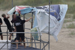 Staff members for the MRV Outer Banks Pro surf tournament take down a banner in Nags Head, N.C., Friday, Sept. 2, 2016, as Tropical Storm Hermine heads toward the Outer Banks. (AP Photo/Tom Copeland)