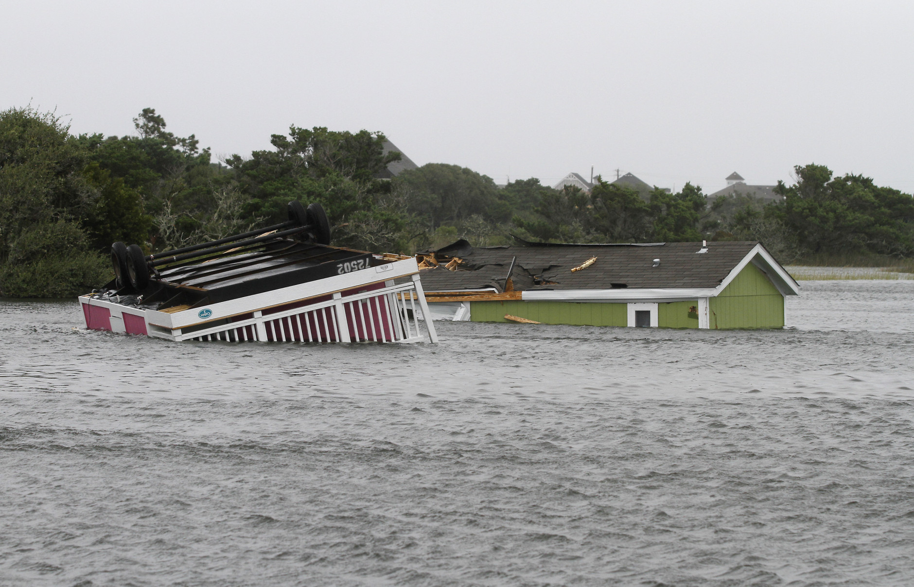 Two trailers sit overturned in the creek behind the Hatteras Sands Campground in Hatteras, N.C., Saturday, Sept. 3, 2016 after Tropical Storm Hermine passed the Outer Banks.  The storm is expected to dump several inches of rain in parts of coastal Virginia, Maryland, Delaware, New Jersey and New York as the Labor Day weekend continues.  (AP Photo/Tom Copeland)