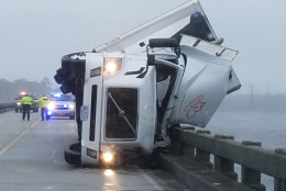 In this photo provided by Tyrrell County Sheriff’s office shows a tipped over 18-wheeler in Columbia, N.C., on Saturday, Sept. 3, 2016.  Tyrrell County Sheriff Darryl Liverman said that high winds tipped over the 18-wheeler, killing its driver and shutting down the U.S. 64 bridge during Tropical Storm Hermine.   (Tyrrell County Sheriff’s office via AP)