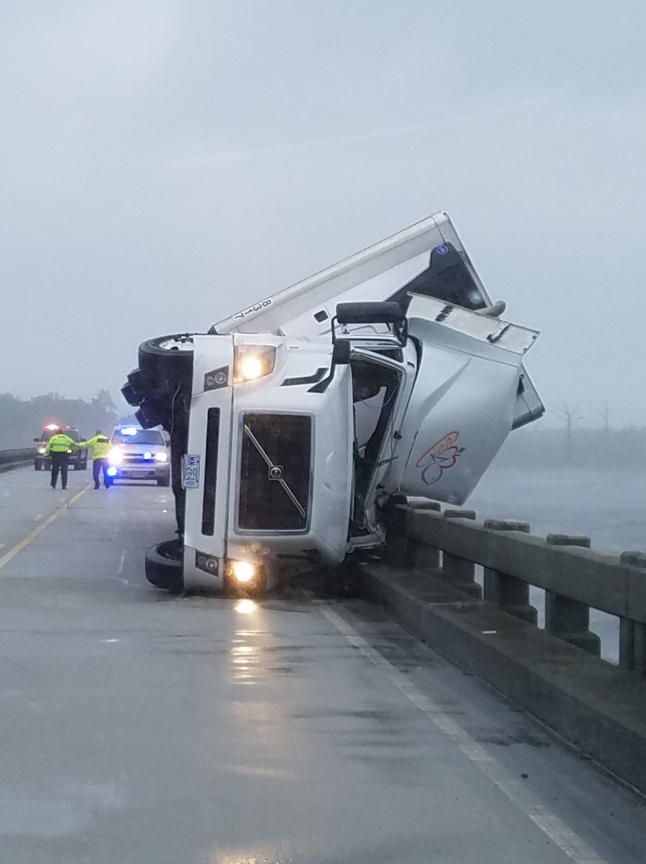 In this photo provided by Tyrrell County Sheriff’s office shows a tipped over 18-wheeler in Columbia, N.C., on Saturday, Sept. 3, 2016.  Tyrrell County Sheriff Darryl Liverman said that high winds tipped over the 18-wheeler, killing its driver and shutting down the U.S. 64 bridge during Tropical Storm Hermine.   (Tyrrell County Sheriff’s office via AP)