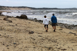 A couple walks along Sagamore Beach as Hermine whips up heavy surf on Cape Cod Bay on Monday, Sept. 5, 2016, in Bourne, Mass. Hermine continued Monday to twist hundreds of miles off shore in the Atlantic Ocean and was expected to keep swimmers and surfers out of beach waters because of its dangerous waves and rip currents on the last day of the long holiday weekend. (AP Photo/William J. Kole)