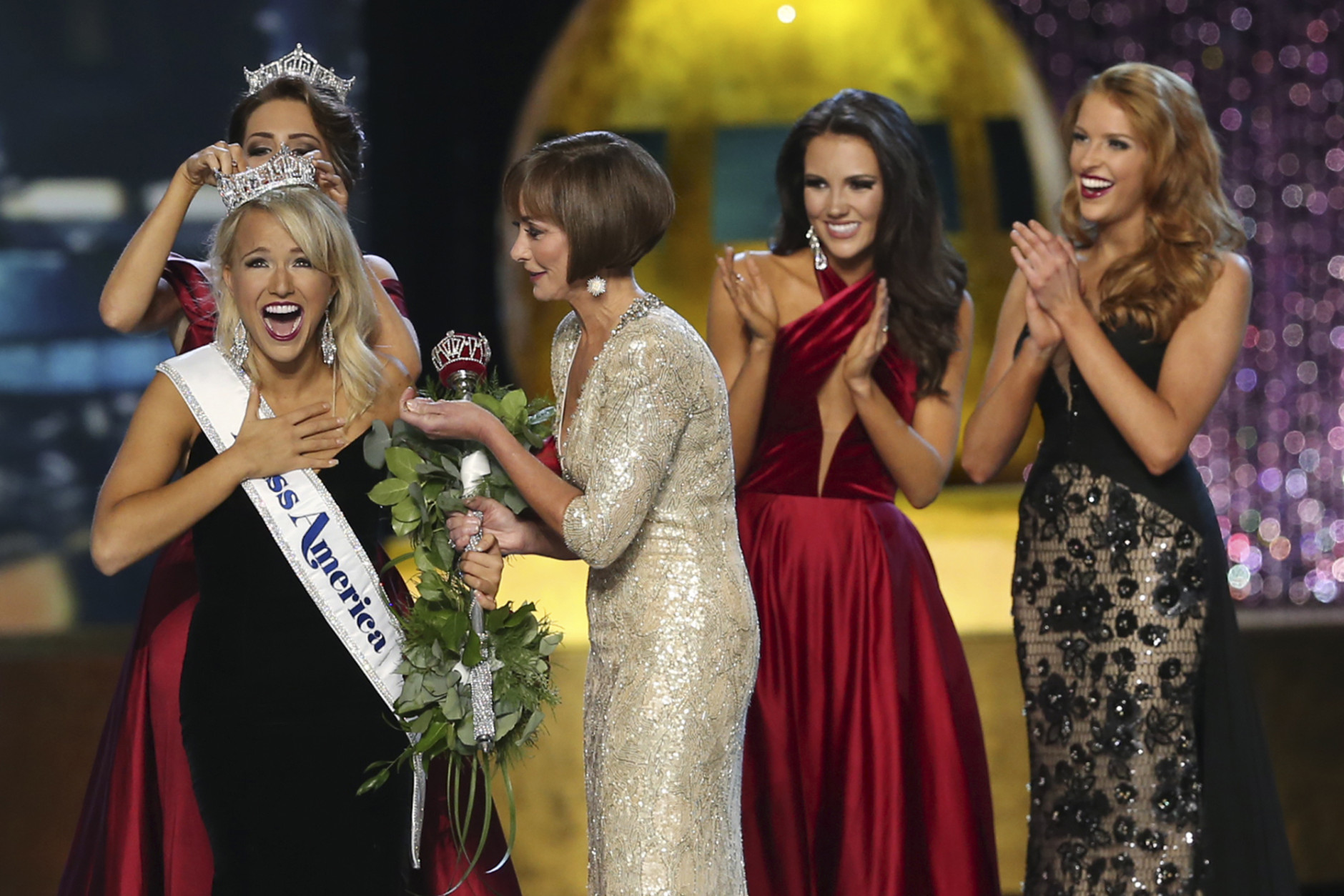 The outgoing Miss America, Betty Cantrell, back left, crowns the Miss America winner Miss Arkansas Savvy Shields, while Lynn Weidner, third right, assists, as Miss Maryland Hannah Brewer, second right, and Miss Texas 2016 Caroline Carothers, look on during the Miss America 2017 pageant, Sunday, Sept. 11, 2016, in Atlantic City, N.J. (AP Photo/Mel Evans)