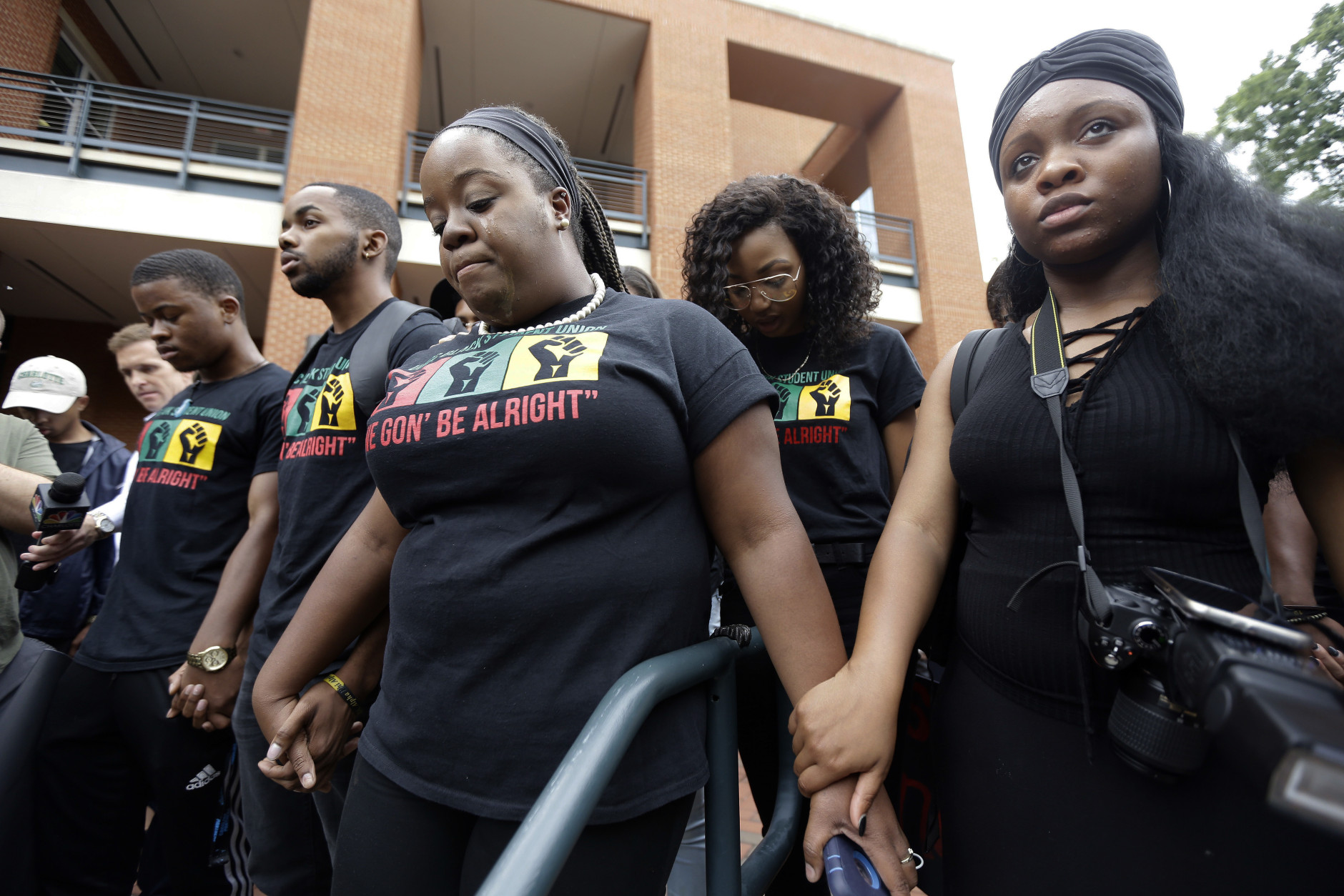 Robbie Miller, center, cries as she and fellow students at the University of North Carolina Charlotte hold a vigil following Tuesday's police shooting of Keith Lamont Scott at The Village at College Downs apartment complex in Charlotte, N.C., Wednesday, Sept. 21, 2016. (AP Photo/Gerry Broome)