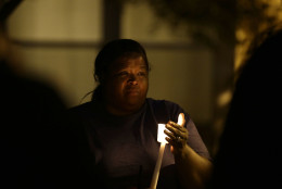A woman holds a candle as people gather for a vigil at the scene of Tuesday's police shooting of Keith Lamont Scott at The Village at College Downs apartment complex in Charlotte, N.C., Wednesday, Sept. 21, 2016. (AP Photo/Gerry Broome)