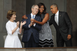 First lady Michelle Obama, center, hugs former President George W. Bush, as President Barack Obama and former first lady Laura Bush walk on stage at the dedication ceremony of the Smithsonian Museum of African American History and Culture on the National Mall in Washington, Saturday, Sept. 24, 2016. (AP Photo/Pablo Martinez Monsivais)
