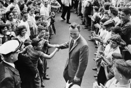 File-This April 16, 1960, file photo shows a grinning Arnold Palmer surrounded by applauding citizens of his native Latrobe,Pa., shaking hands with a couple of enthusiastic boys. Palmer, who made golf popular for the masses with his hard-charging style, incomparable charisma and a personal touch that made him known throughout the golf world as "The King," died Sunday, Sept. 25, 2016, in Pittsburgh. He was 87.  (AP Photo/File)