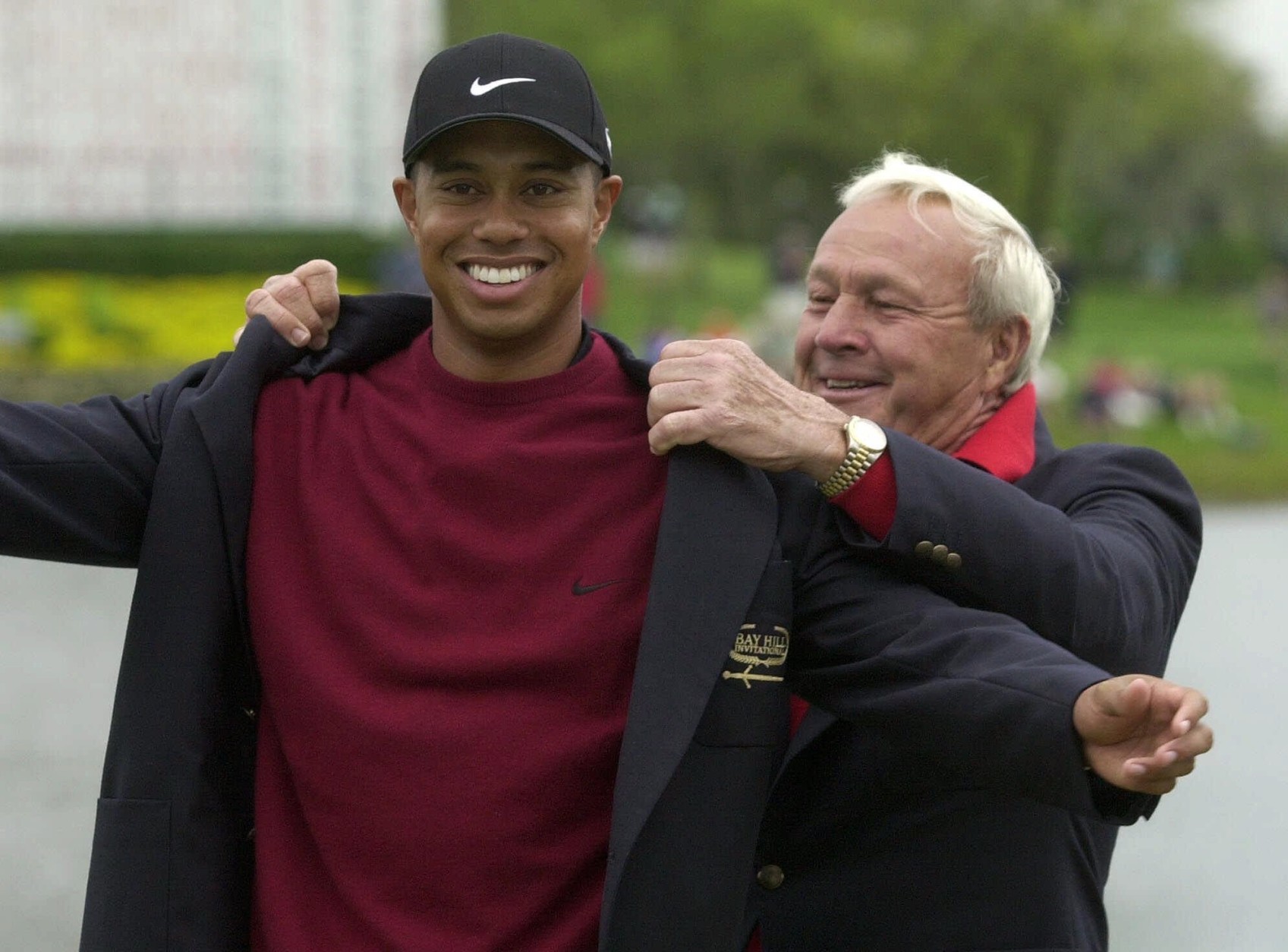 File-This March 18, 2001, file photo shows Tiger Woods, left, being helped into his jacket for winning the Bay Hill Invitational by tournament host Arnold Palmer  in Orlando, Fla. Woods Palmer, who made golf popular for the masses with his hard-charging style, incomparable charisma and a personal touch that made him known throughout the golf world as "The King," died Sunday, Sept. 25, 2016, in Pittsburgh. He was 87.  (AP Photo/Scott Audette, File)