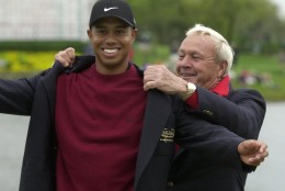 File-This March 18, 2001, file photo shows Tiger Woods, left, being helped into his jacket for winning the Bay Hill Invitational by tournament host Arnold Palmer  in Orlando, Fla. Woods Palmer, who made golf popular for the masses with his hard-charging style, incomparable charisma and a personal touch that made him known throughout the golf world as "The King," died Sunday, Sept. 25, 2016, in Pittsburgh. He was 87.  (AP Photo/Scott Audette, File)