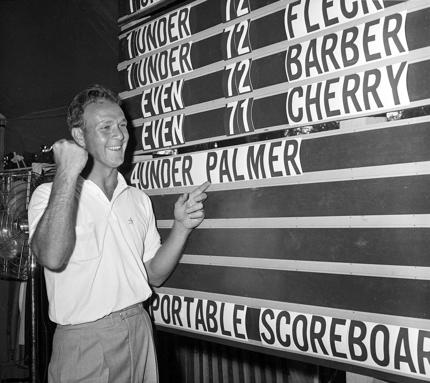 FILE - This June 19, 1960, file photo shows Arnold Palmer pointing to his name on the press tent scoreboard showing his four-under-par total, for 72 holes, during the National Open golf tournament at the Cherry Hills Country Club in Denver, Colo. Palmer, who made golf popular for the masses with his hard-charging style, incomparable charisma and a personal touch that made him known throughout the golf world as "The King," died Sunday, Sept. 25, 2016, in Pittsburgh. He was 87. (AP Photo/File)