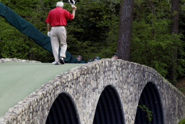 File- This April 9, 2004, file photo shows Arnold Palmer walking across the Hogan Bridge on the 12th fairway for the final time in Masters competition during the second round of the Masters golf tournament at the Augusta National Golf Club in Augusta, Ga.  Palmer, who made golf popular for the masses with his hard-charging style, incomparable charisma and a personal touch that made him known throughout the golf world as "The King," died Sunday, Sept. 25, 2016, in Pittsburgh. He was 87. (AP Photo/Amy Sancetta, File)