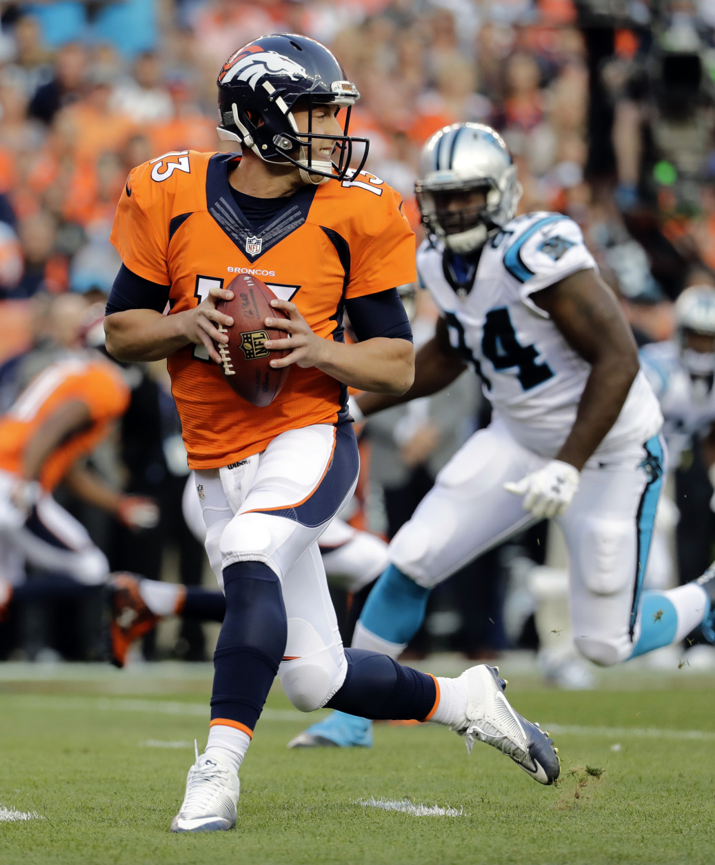 Denver Broncos quarterback Trevor Siemian (13) looks to pass as Carolina Panthers defensive end Kony Ealy (94) pursues during the first half of an NFL football game, Thursday, Sept. 8, 2016, in Denver. (AP Photo/Jack Dempsey)